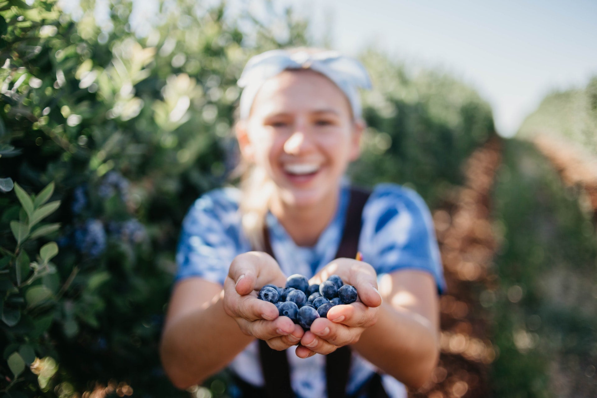 Young woman holding blueberries, a blood sugar-balancing food